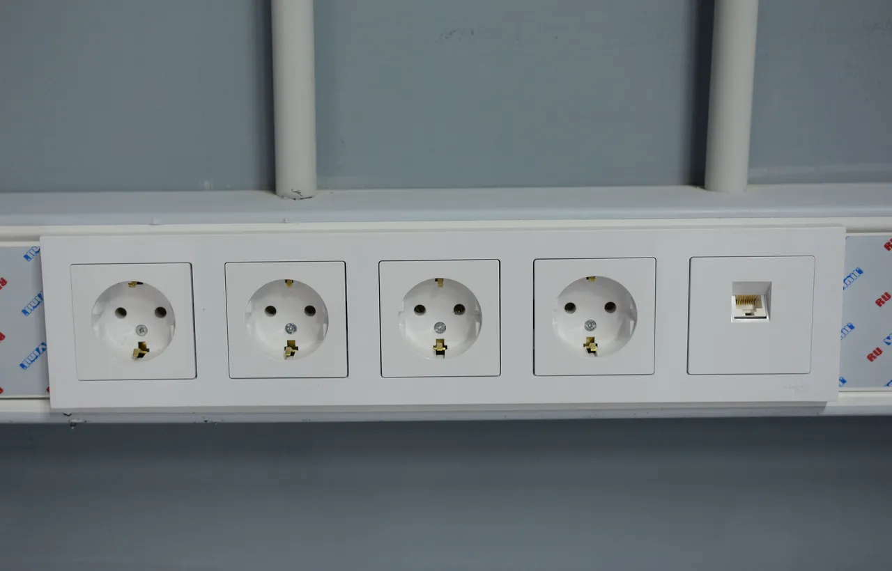 Блок из четырёх розеток и компьютерной розетки в кабель-канале в офисе